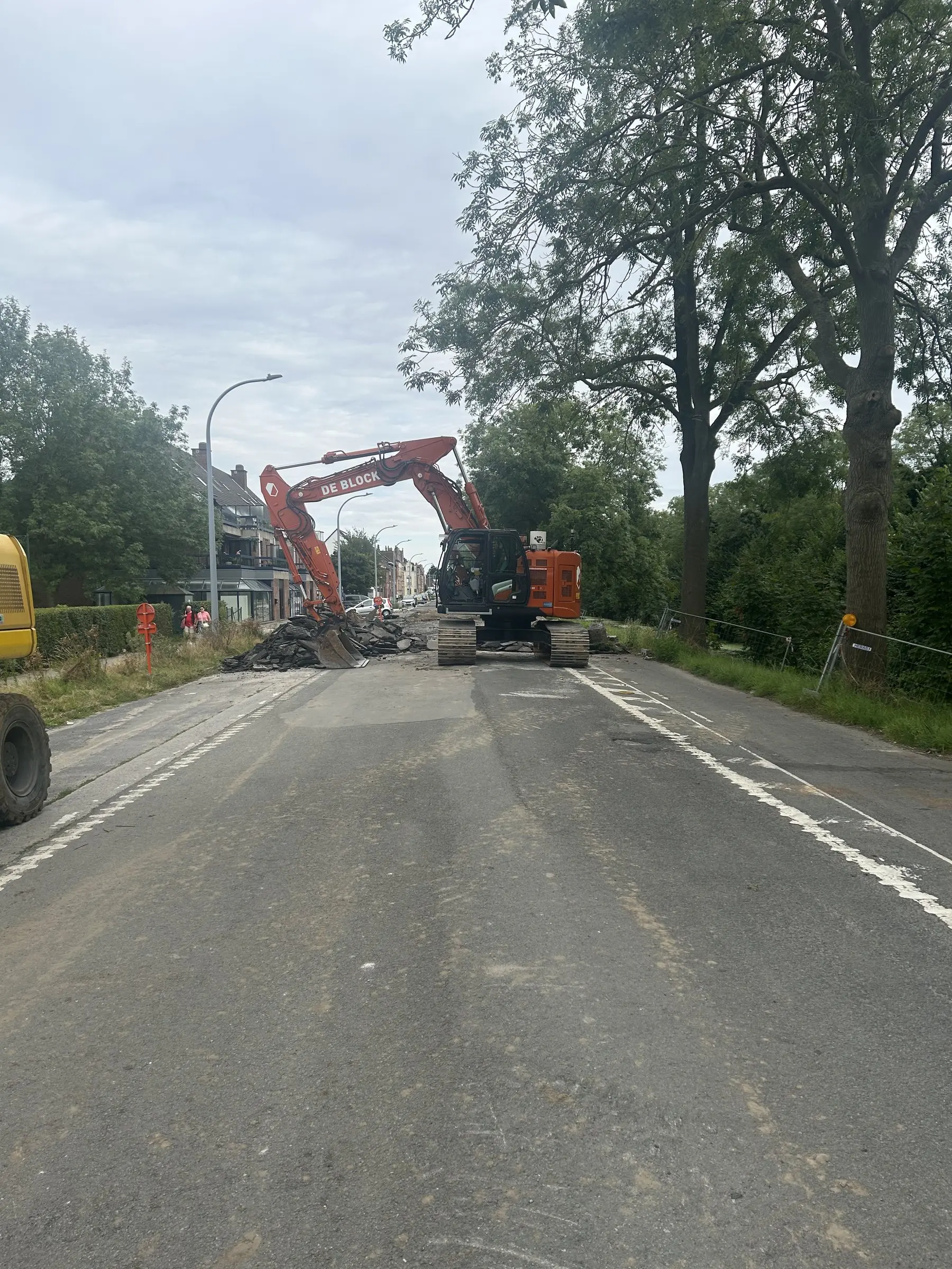 Graafmachine aan het werk verderop op een lange straat