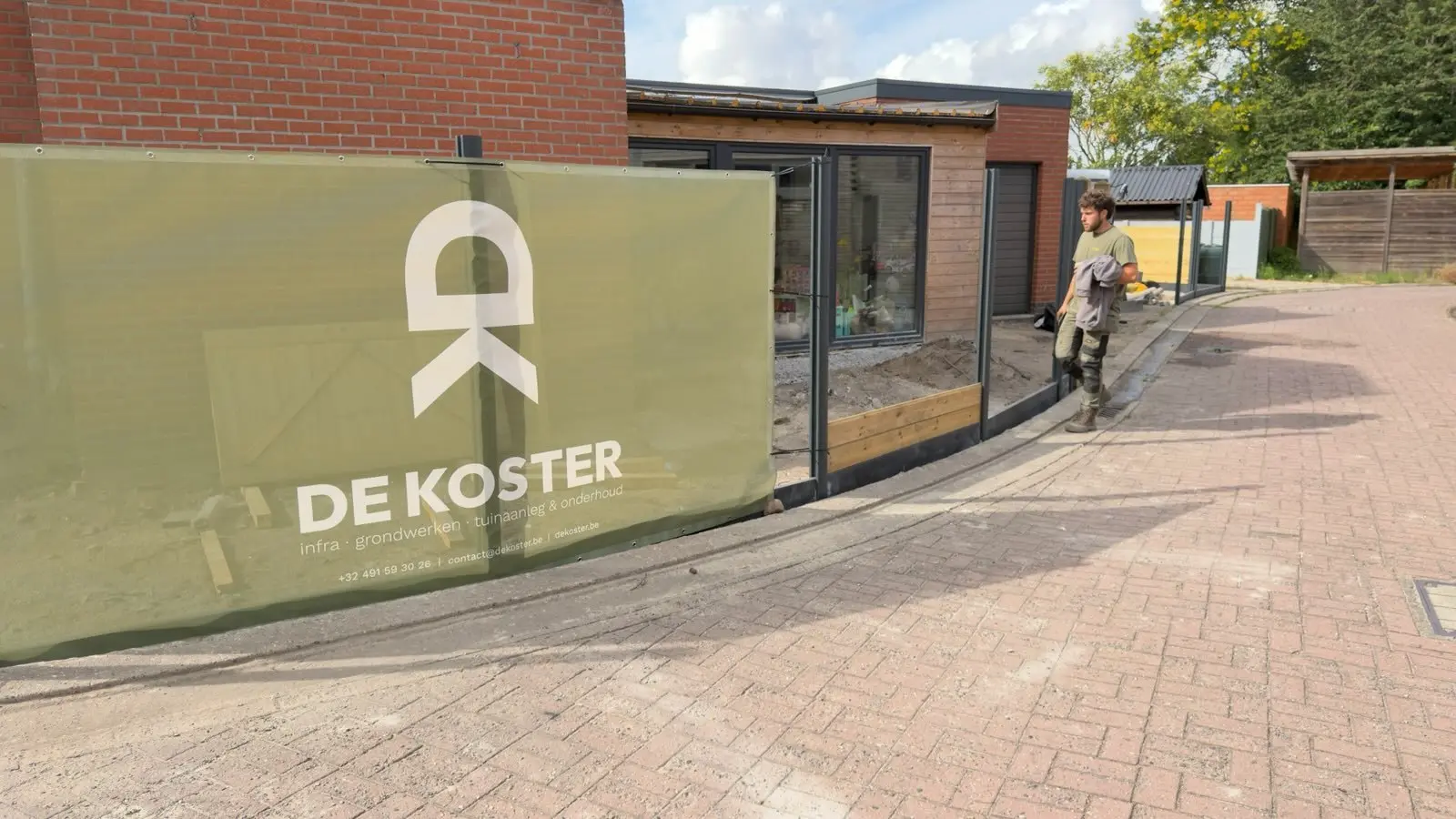 Groen scherm met logo tijdens de werken aan de afsluiting