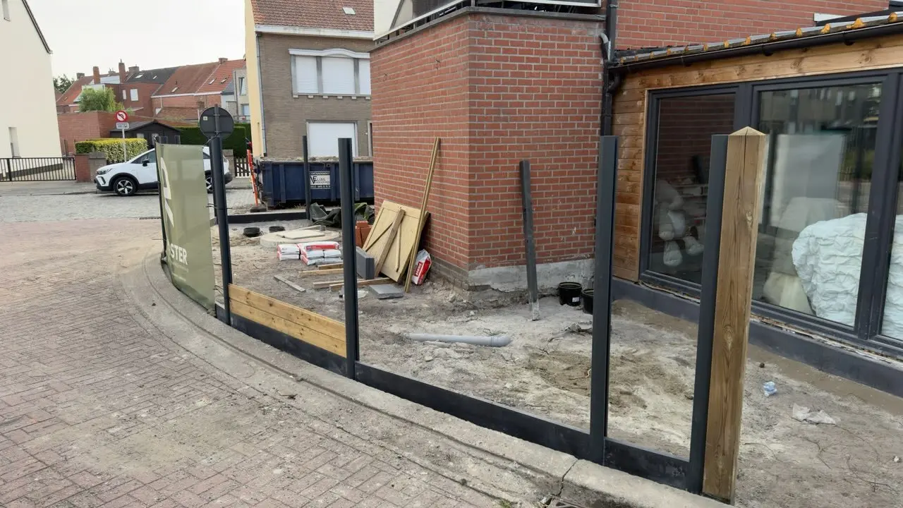 Gebogen afsluiting met werfmateriaal naast de gevel