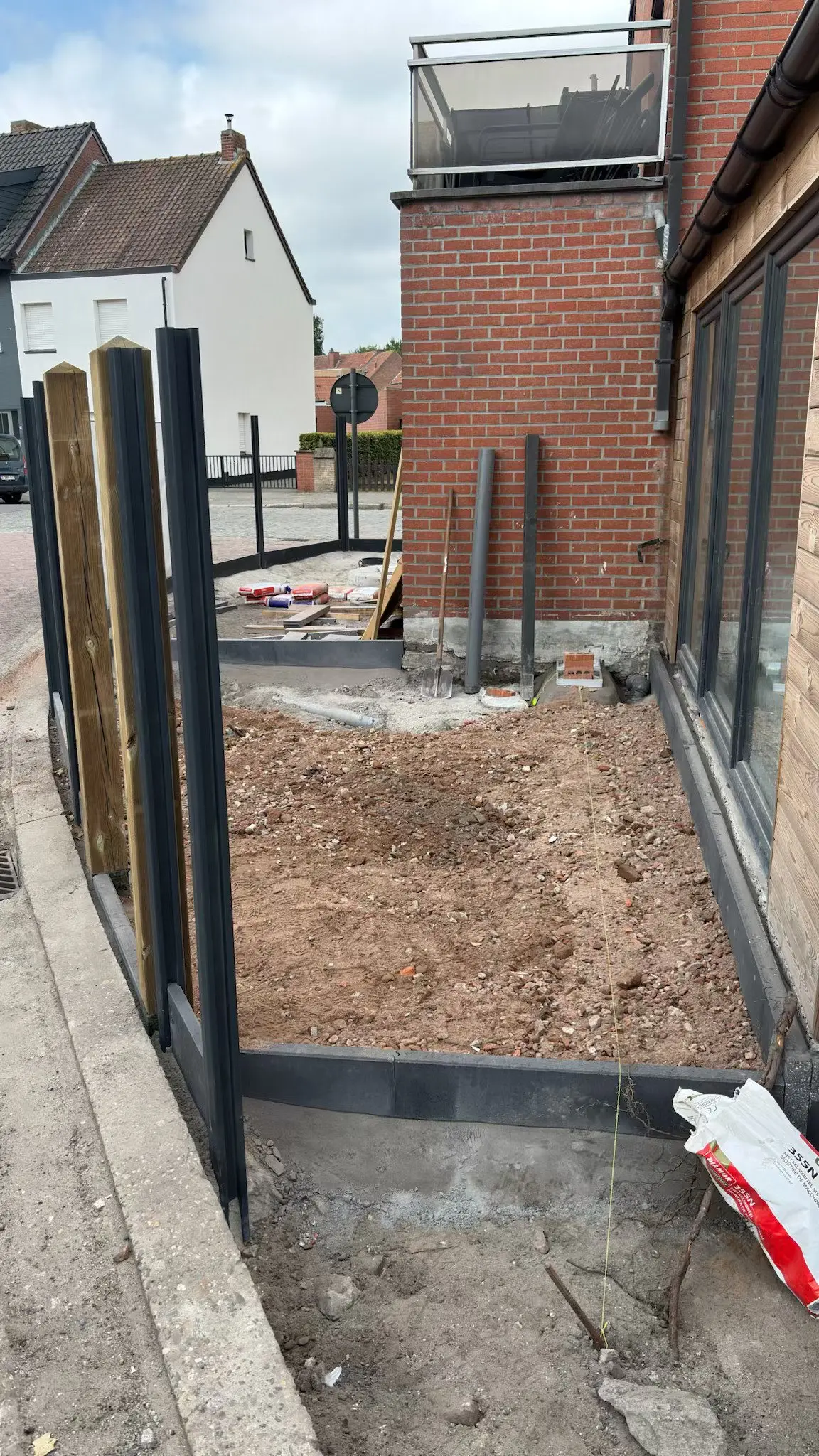 Afgebakende tuinzone met grond naast het houten gevelpaneel