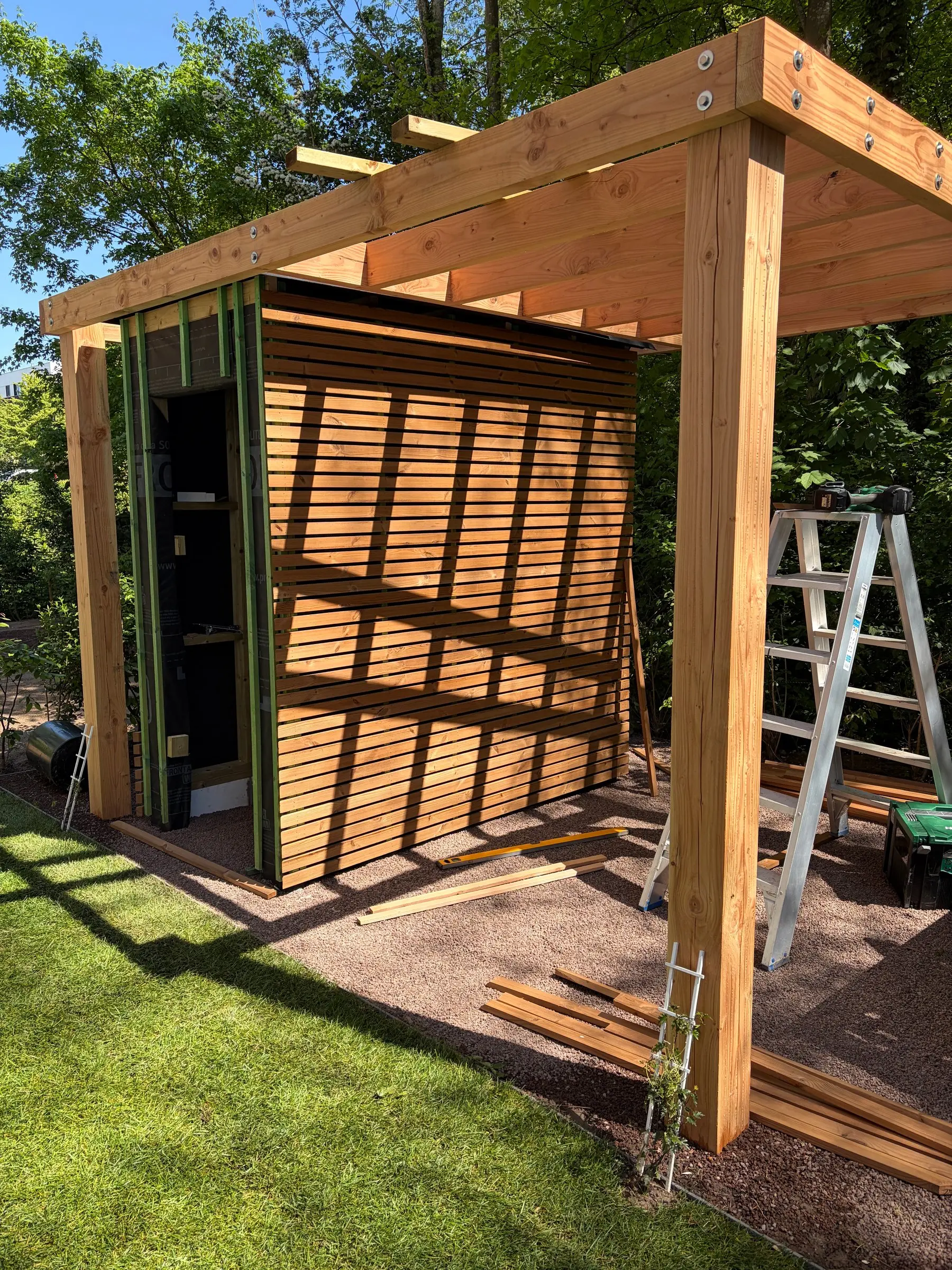 Pergola in warm licht met zicht op het tuinhuis