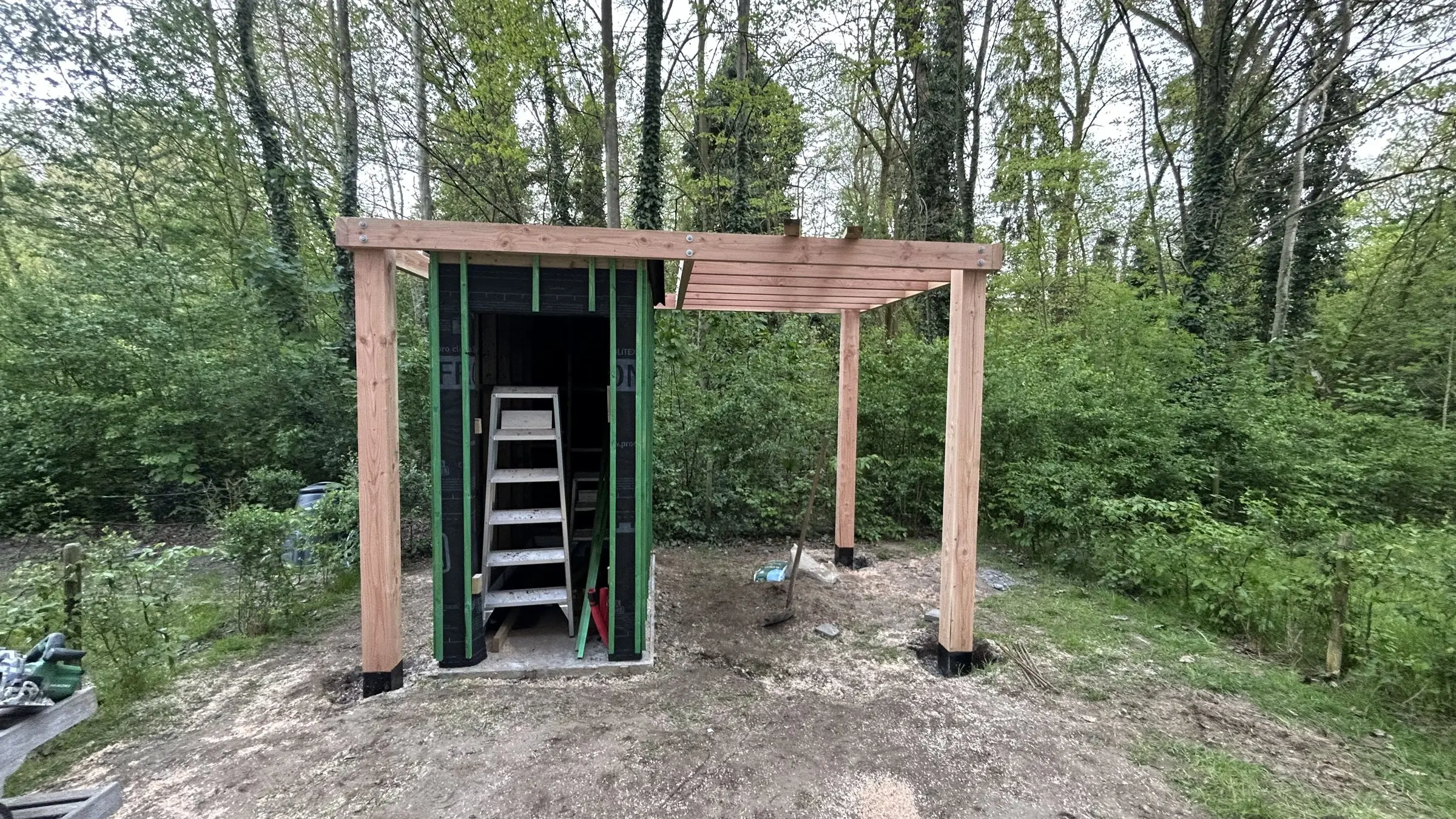 Tuinhuis in opbouw met ladder en pergoladak
