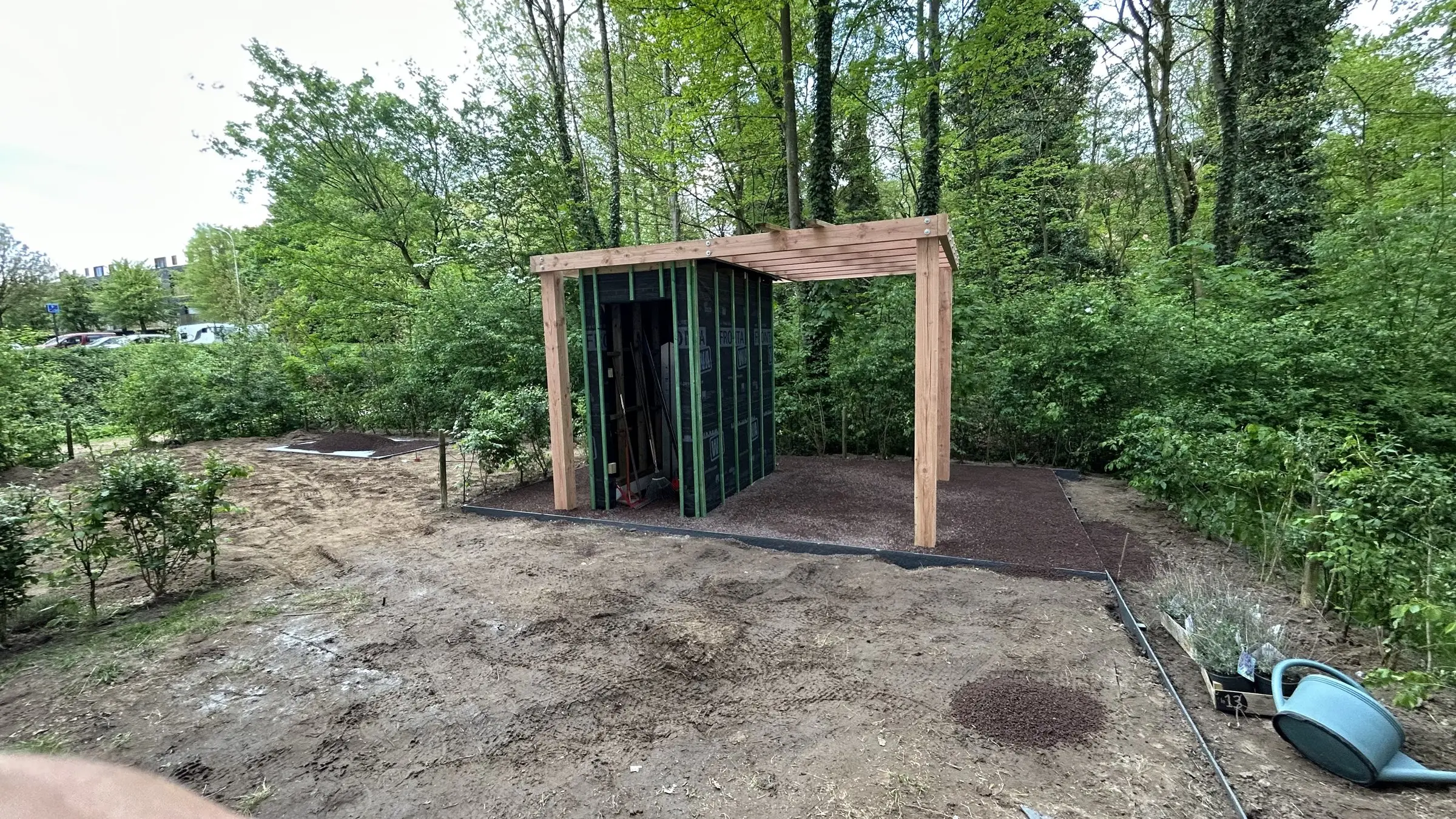 Overzicht van de werf met tuinhuis en pergola in het groen