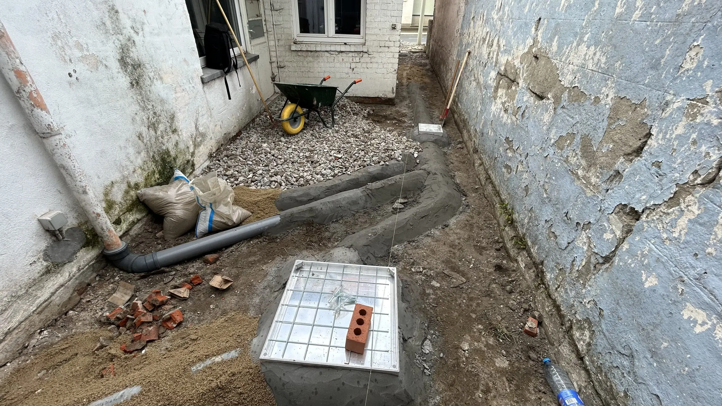 Nieuwe put met deksel omringd door zand en buis