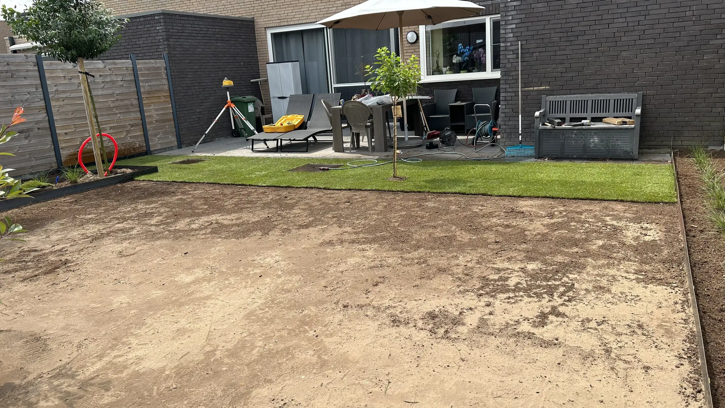 Eerste graszoden aan de terraszijde, de rest nog zand