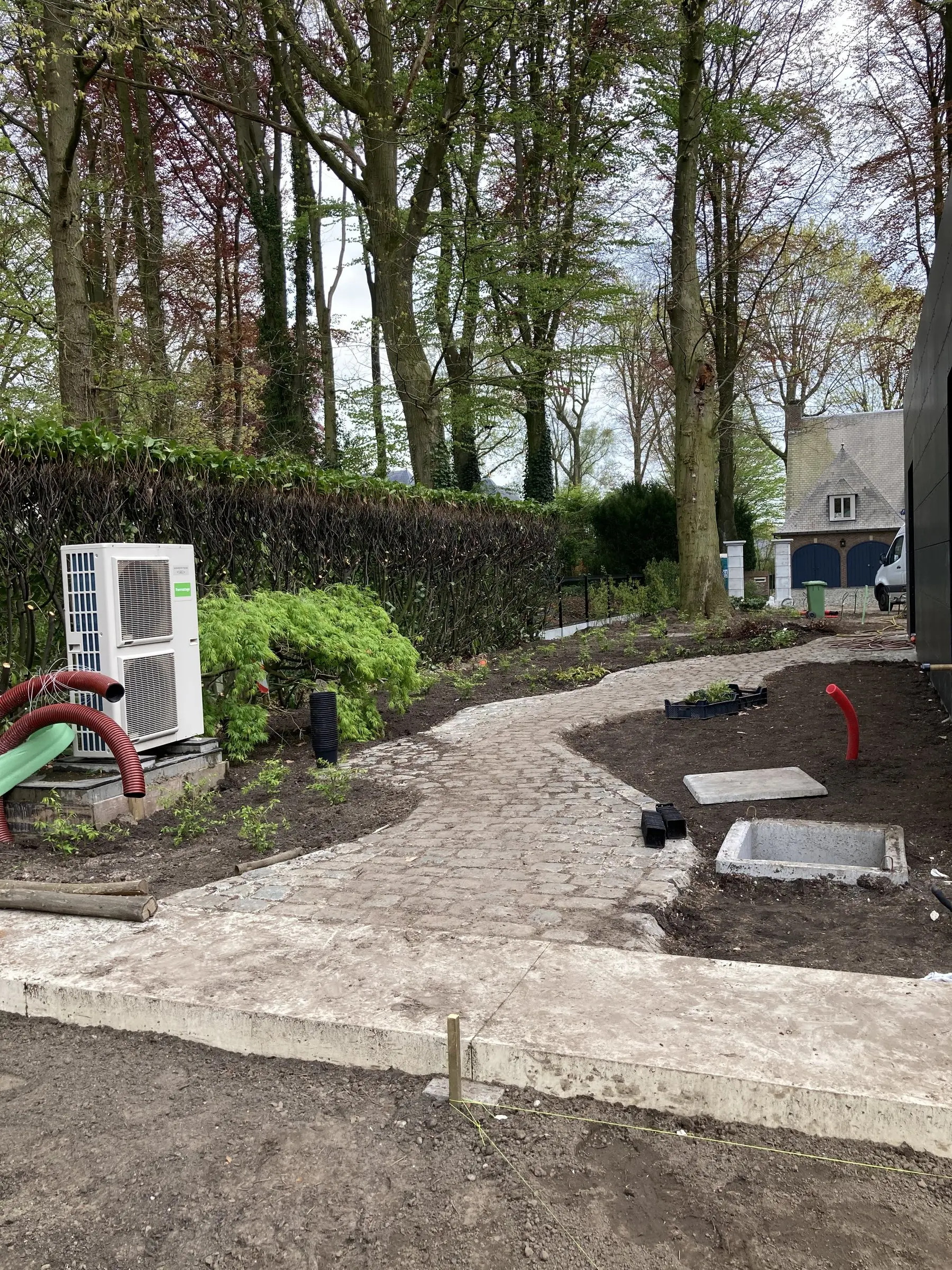 Kasseipad langs de gevel met eerste beplanting
