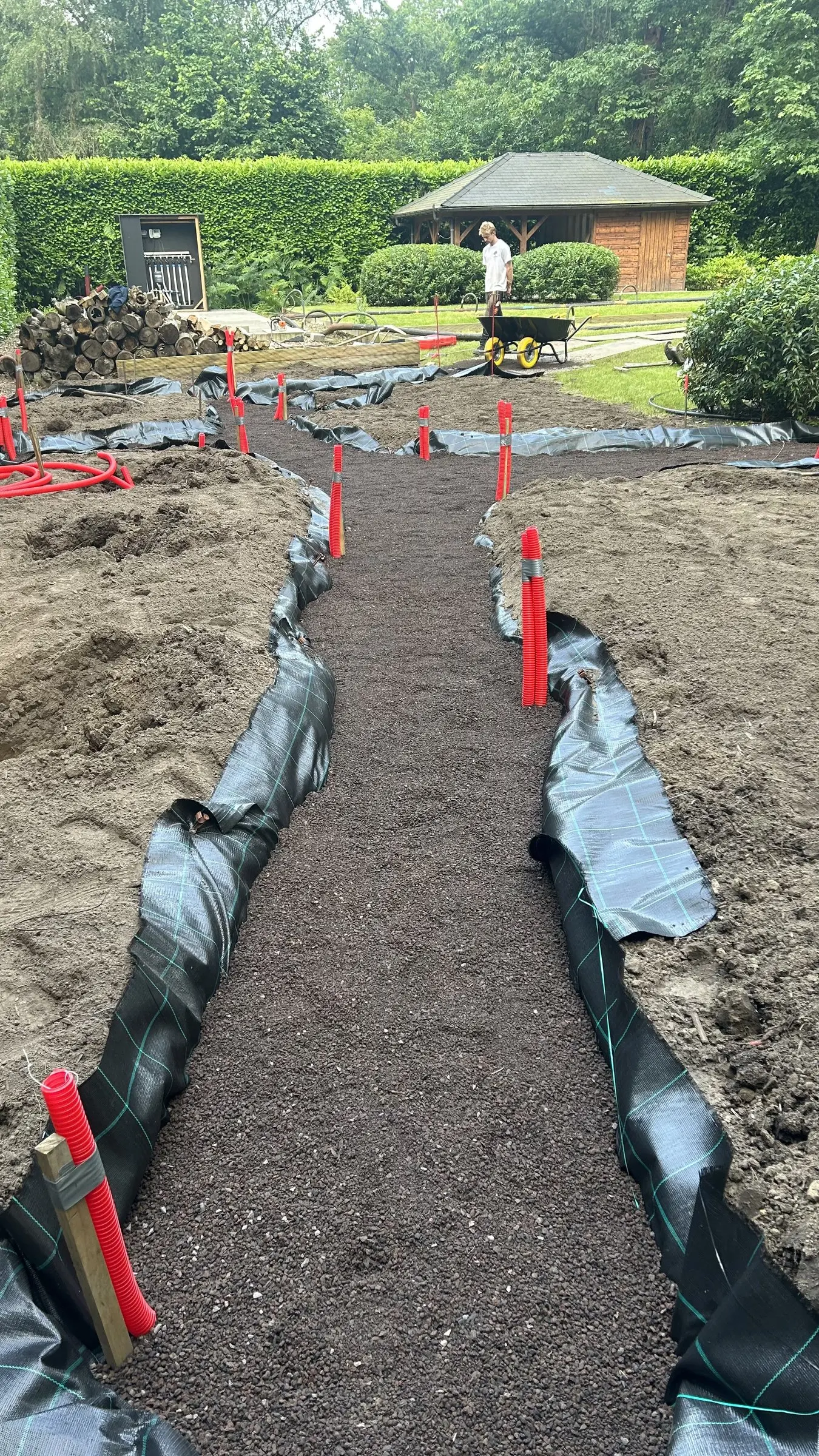 Smal pad met doek en rode markering, zicht naar het tuinhuis