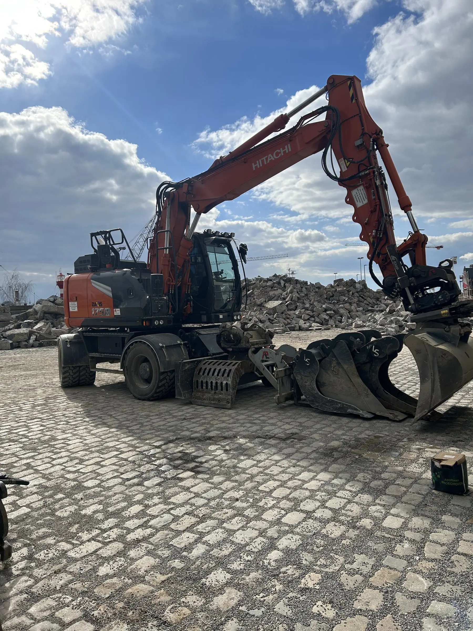 Wielgraafmachine met sorteergrijper op kasseien